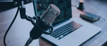 un ordinateur avec un micro évoquant le podcast radio