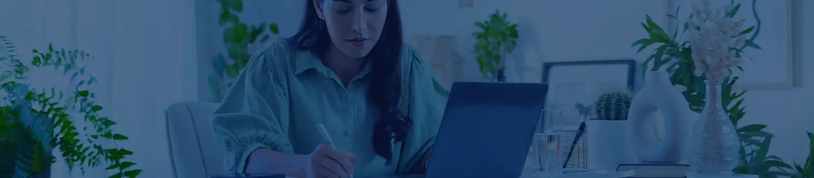 Femme travaillant sur un ordinateur portable et prenant des notes
